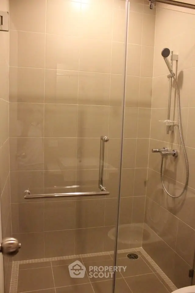 Modern bathroom with sleek glass shower enclosure and contemporary fixtures.
