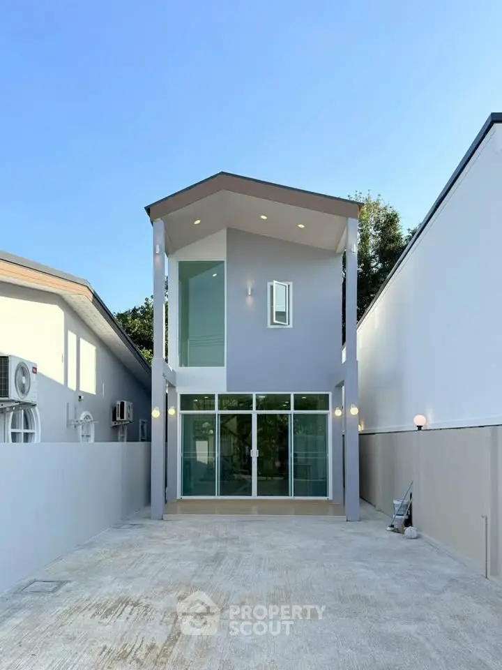 Modern two-story house with sleek design and spacious driveway, perfect for contemporary living.