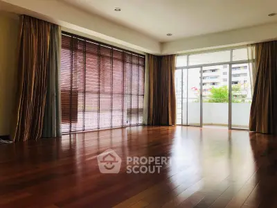 Spacious living room with wooden flooring and large windows in modern apartment