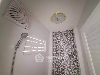 Modern bathroom with stylish patterned tiles and showerhead