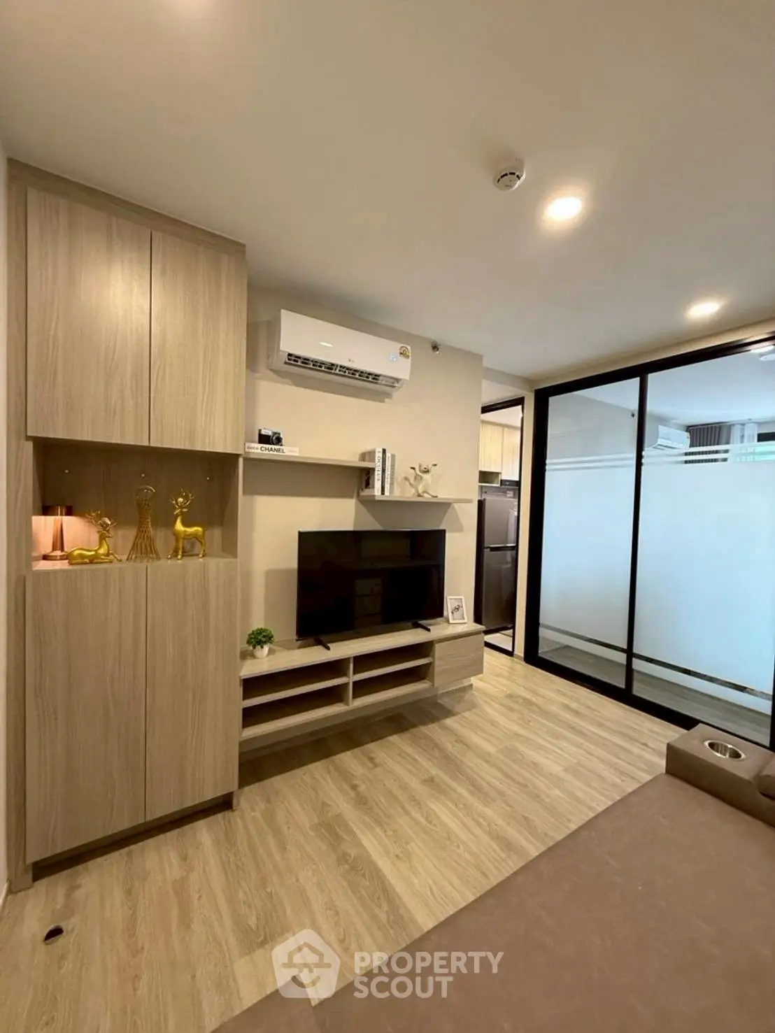 Modern living room with sleek wooden cabinetry and glass partition