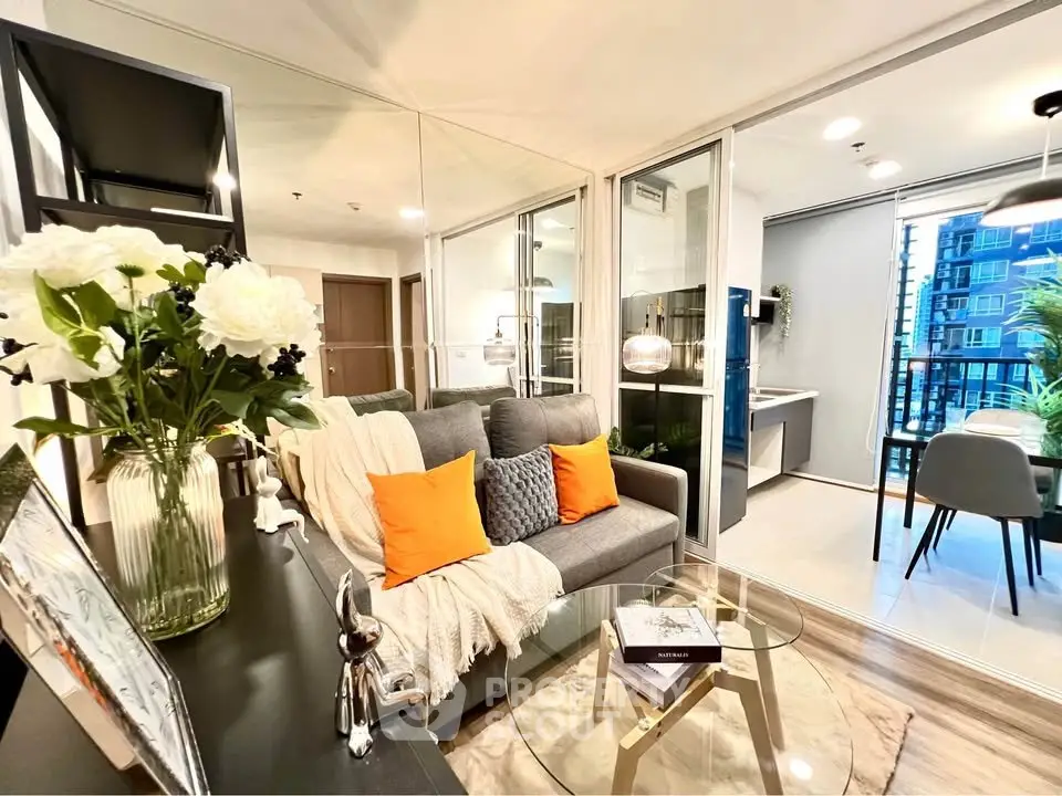 Modern living room with cozy sofa, glass coffee table, and open balcony view in stylish apartment.