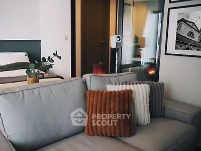 Modern living room with cozy sofa and stylish decor in open-plan apartment.