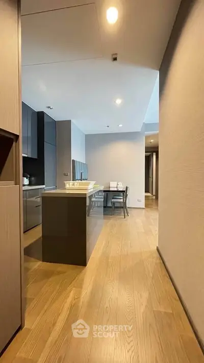 Modern kitchen with sleek design and open layout, featuring wooden flooring and contemporary dining area.