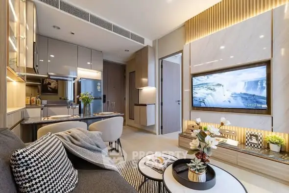 Modern living room with open kitchen, stylish decor, and wall-mounted TV in a contemporary apartment.