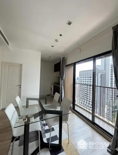 Modern dining area with glass table and city view balcony in high-rise apartment