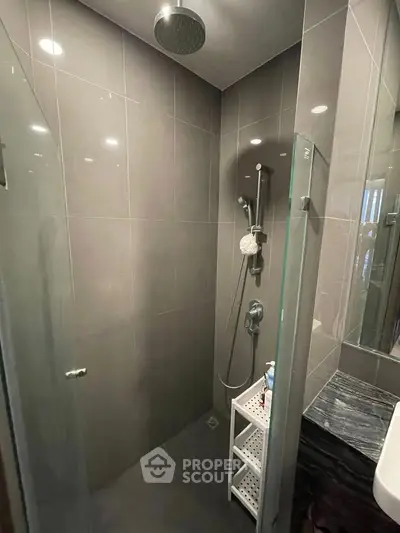 Modern bathroom with sleek shower and elegant dark tiles