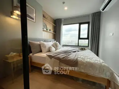 Modern bedroom with large window offering stunning city view, cozy decor, and ample natural light.