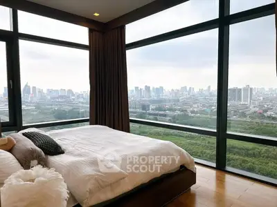 Luxurious bedroom with panoramic city view from floor-to-ceiling windows.