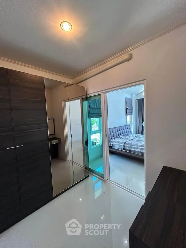 Modern bedroom with sleek wardrobe and glass sliding doors