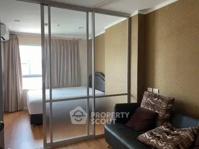 Modern bedroom with glass partition and cozy seating area in a stylish apartment.