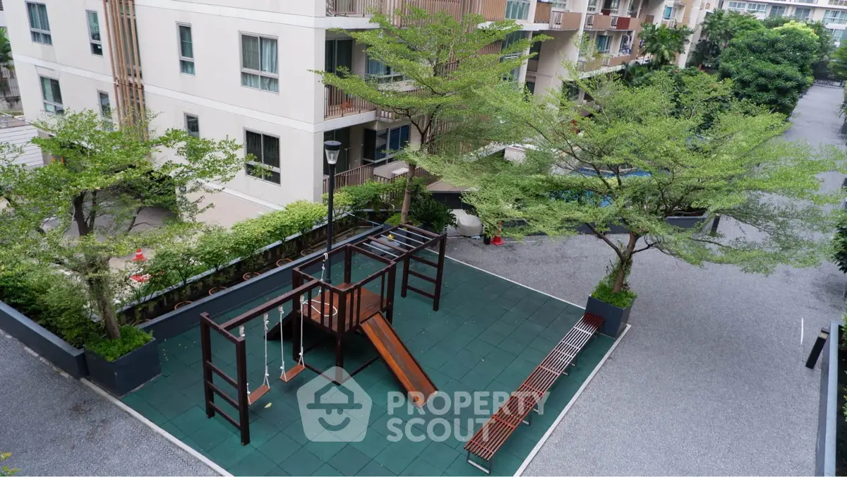 Charming residential playground with modern equipment and lush greenery.