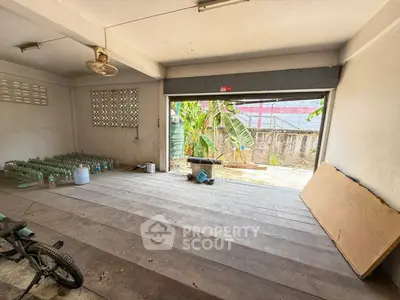 Spacious garage with open layout and garden view, ideal for storage or workshop space.