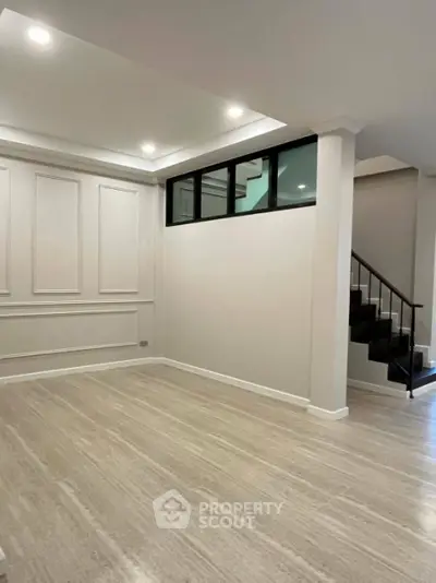 Spacious modern living room with elegant staircase and stylish wall paneling