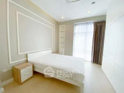Bright and spacious bedroom with modern design and large window for natural light.