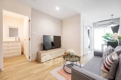 Modern living room with stylish decor and natural light, featuring a sleek TV setup and cozy seating area.