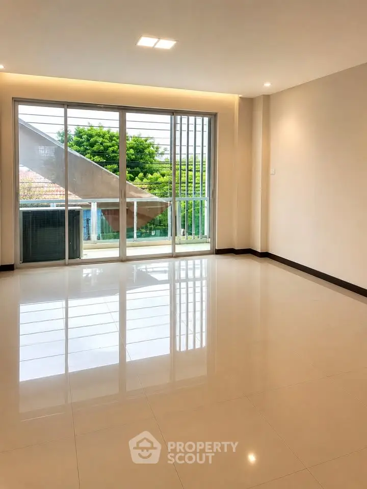 Spacious living room with large windows and garden view, perfect for natural light lovers.