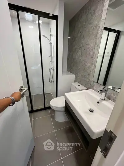 Modern bathroom with sleek shower and elegant fixtures in contemporary apartment.