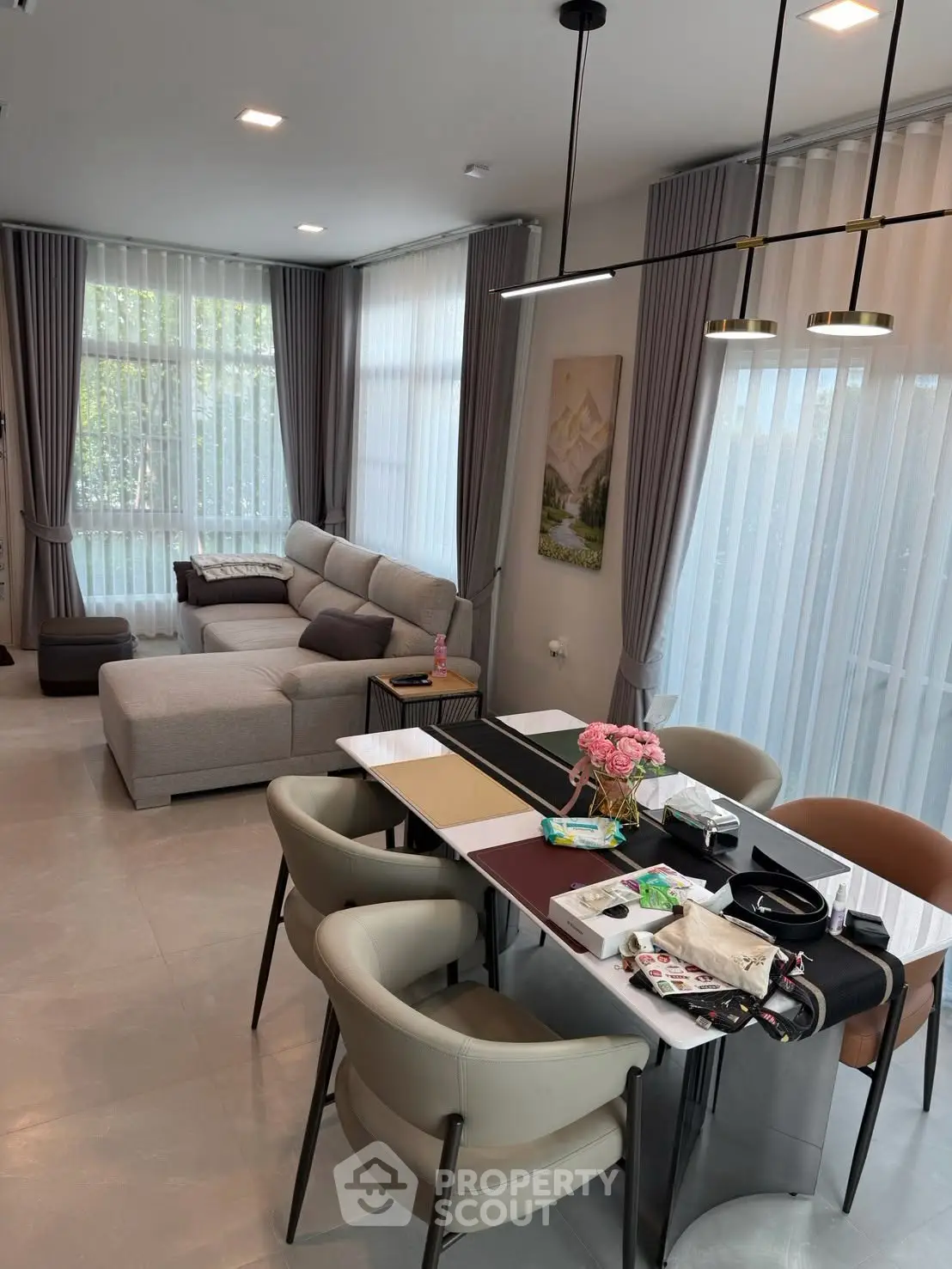 Spacious modern living room with elegant dining area and large windows for natural light.