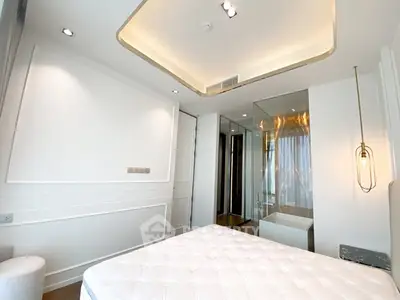 Modern bedroom with stylish lighting and glass-enclosed bathroom in luxury apartment.