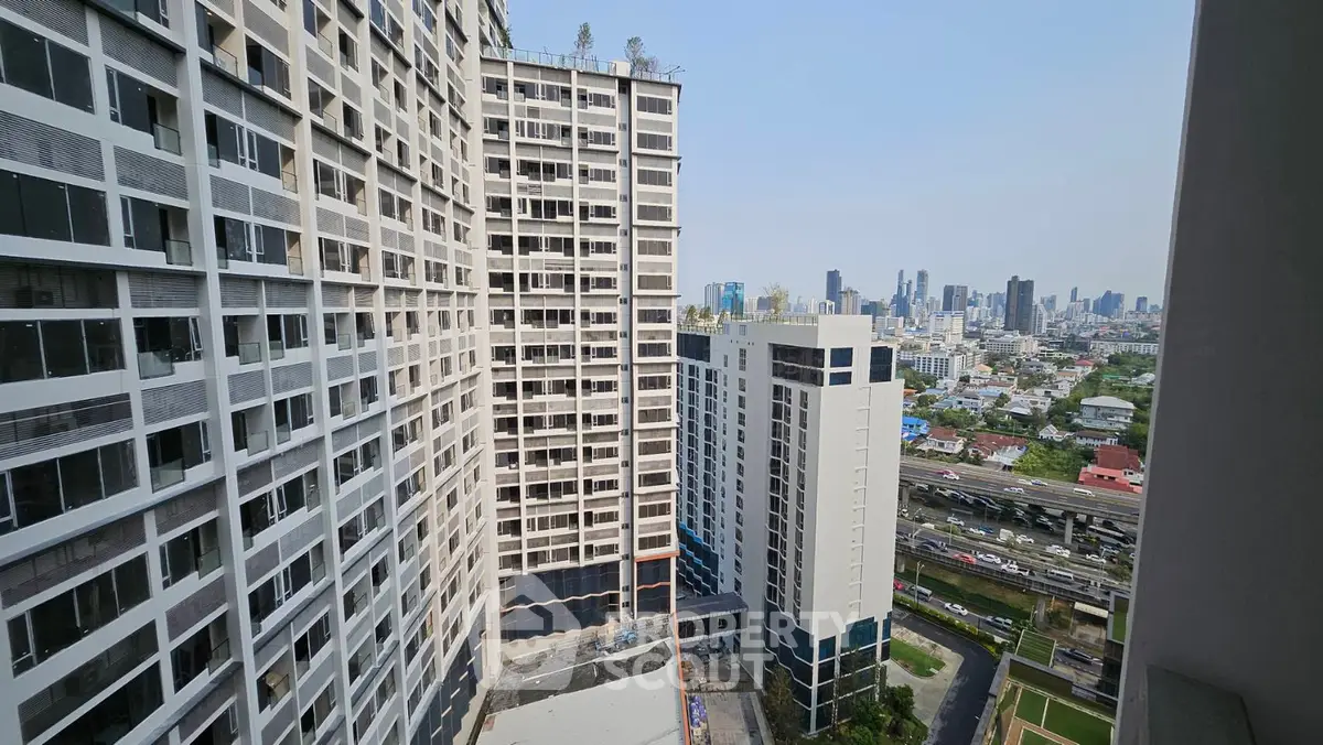 Stunning cityscape view from high-rise apartment balcony showcasing modern urban living.