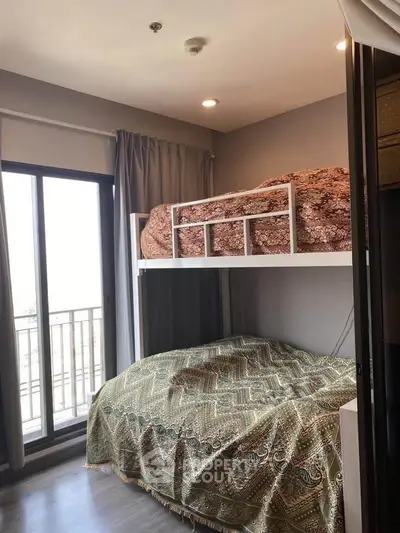 Cozy bedroom with bunk bed and balcony access in modern apartment