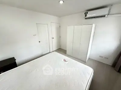 Minimalist bedroom with white wardrobe and air conditioning unit