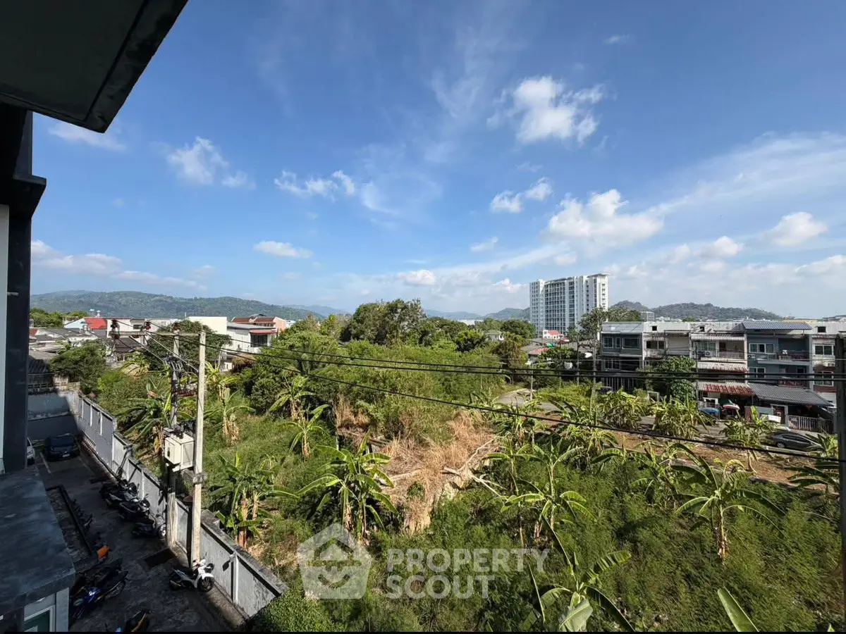 Stunning cityscape view with lush greenery and distant mountains, perfect for serene living.