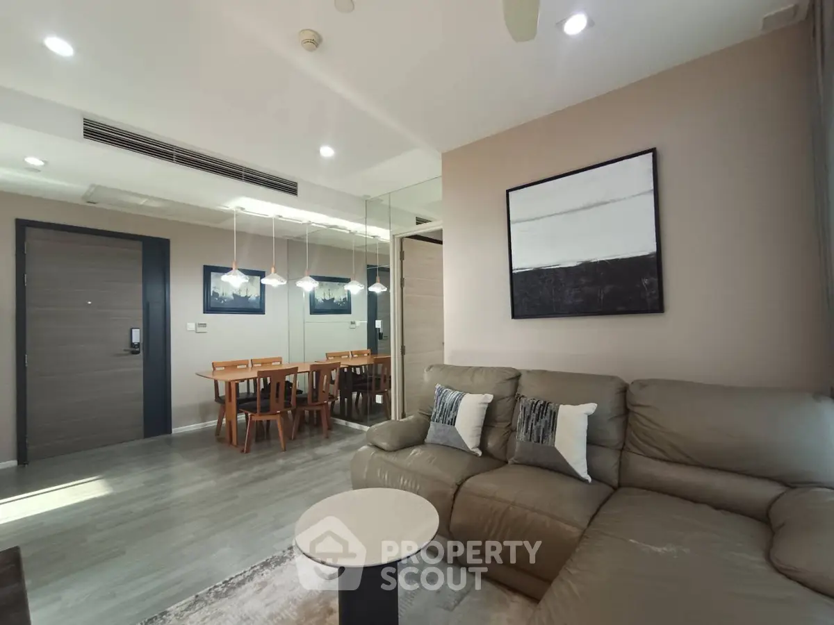 Modern living room with stylish decor and dining area in open layout apartment.