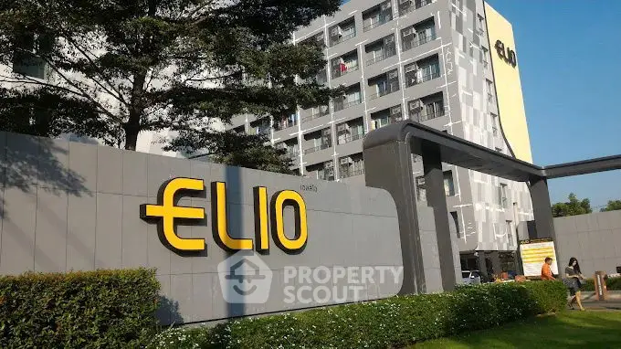 Modern condominium building with stylish entrance and lush greenery.