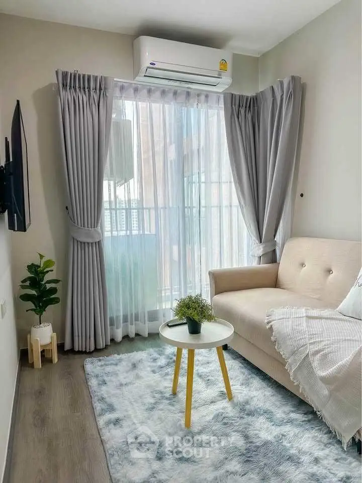 Charming living room with cozy sofa, stylish rug, and balcony view