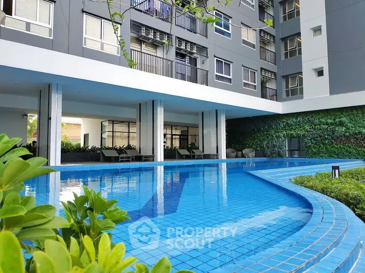 Modern apartment building with a luxurious outdoor pool and lush greenery.