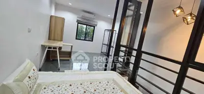Modern bedroom with stylish decor and ample natural light, featuring a cozy bed and sleek furniture.
