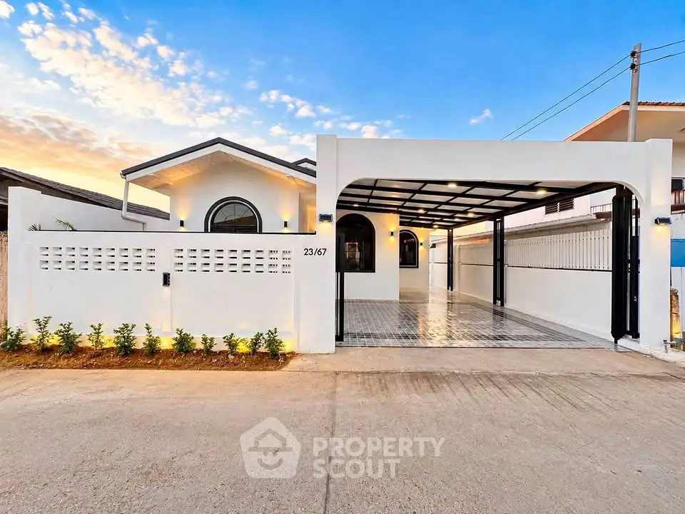 Stunning modern house exterior with spacious driveway and elegant lighting at sunset.
