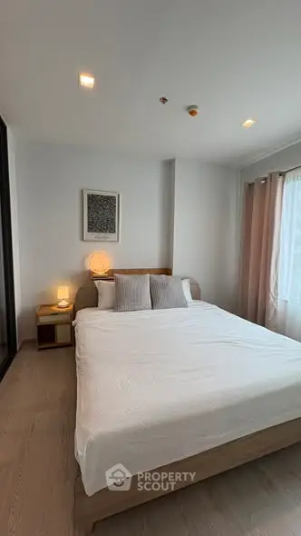 Modern bedroom with cozy lighting and minimalist decor in a stylish apartment.