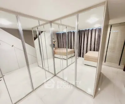 Spacious mirrored bedroom with modern design and ample natural light