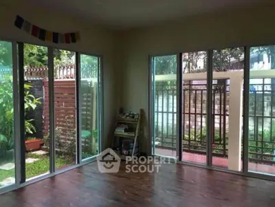 Spacious room with large windows overlooking a lush garden, perfect for natural light lovers.