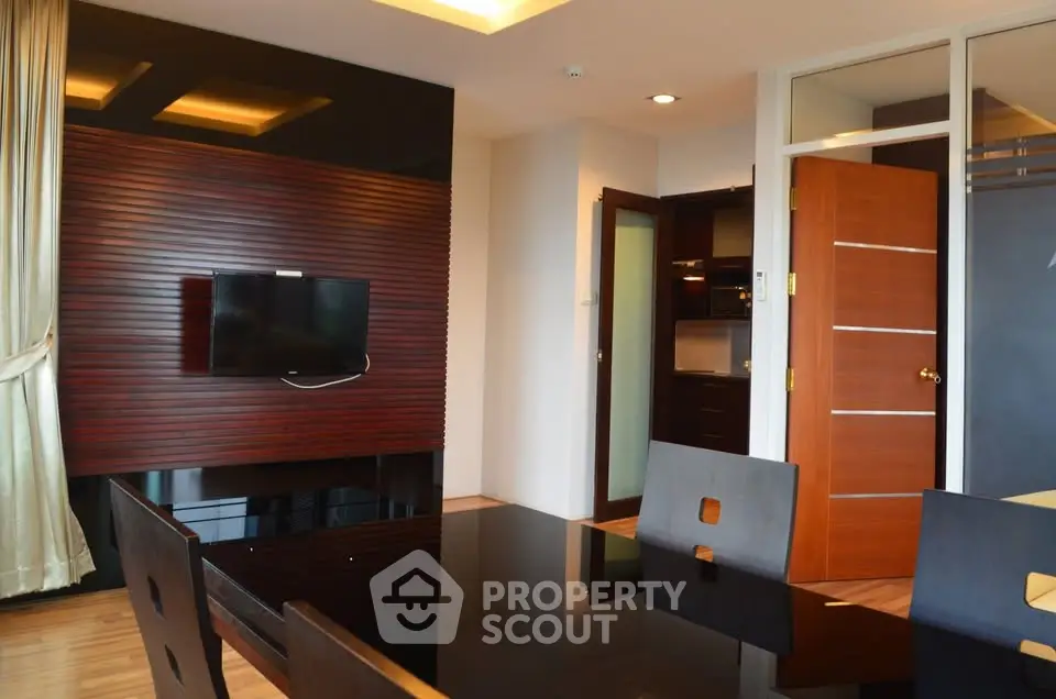 Modern dining area with sleek wooden accents and wall-mounted TV