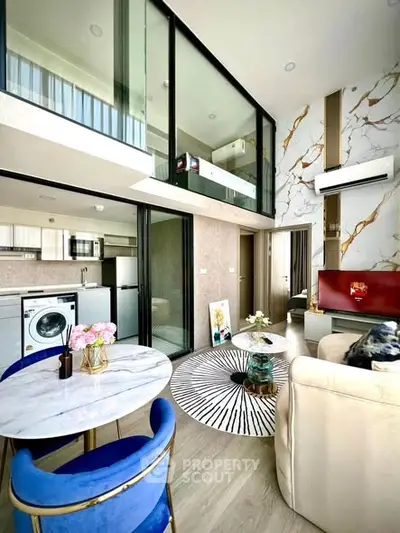 Luxurious modern living room with high ceilings, stylish decor, and open kitchen layout in a chic apartment.