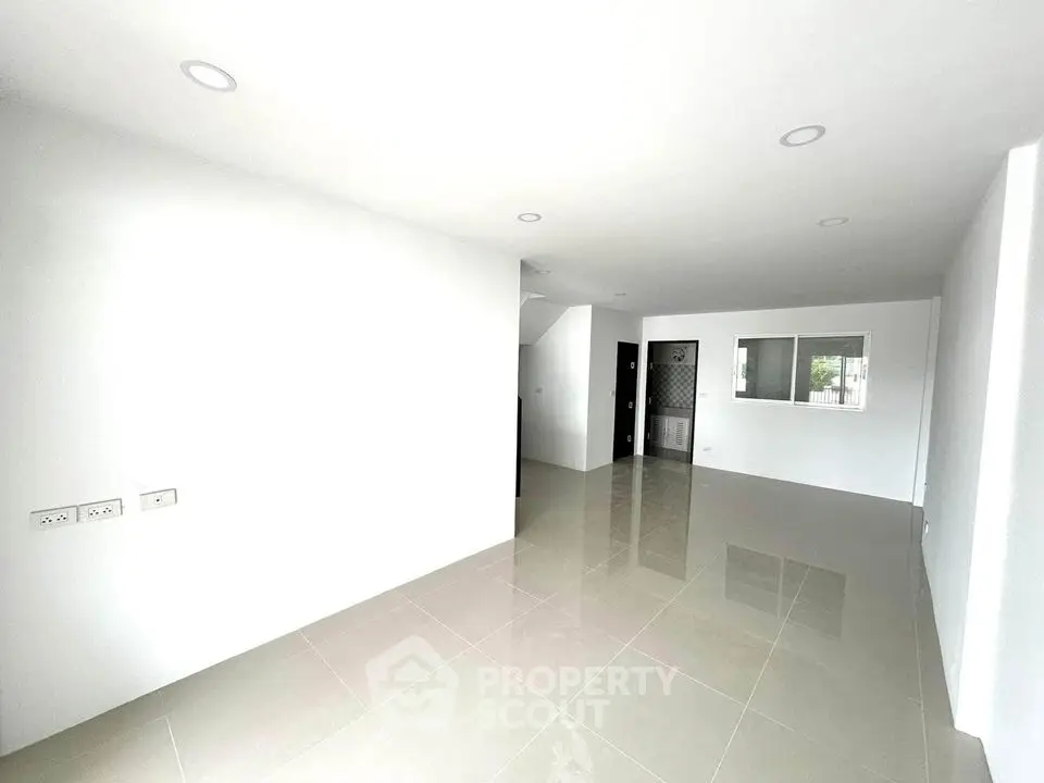 Spacious modern living room with glossy tiled floors and white walls