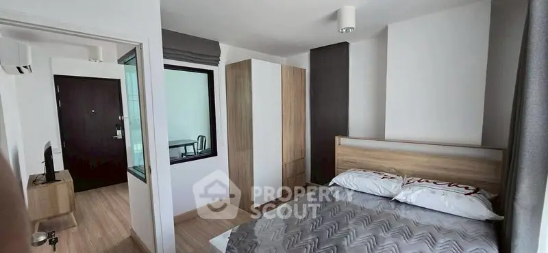 Modern bedroom with stylish decor and natural light, featuring a cozy bed and sleek wardrobe.