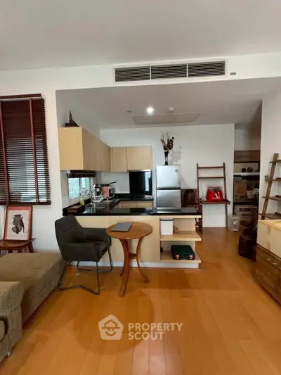 Modern open-layout kitchen with sleek appliances and cozy seating area, perfect for urban living.
