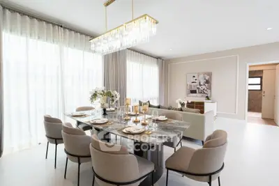 Luxurious open-plan living and dining area with elegant decor and chandelier.