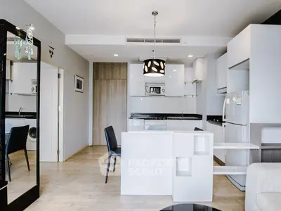 Modern open-layout kitchen with sleek white cabinetry and dining area in a stylish apartment.