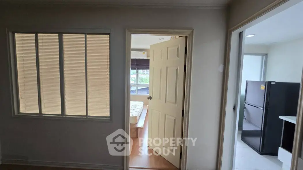 Cozy apartment interior with bedroom and kitchen view, featuring modern appliances and natural light.