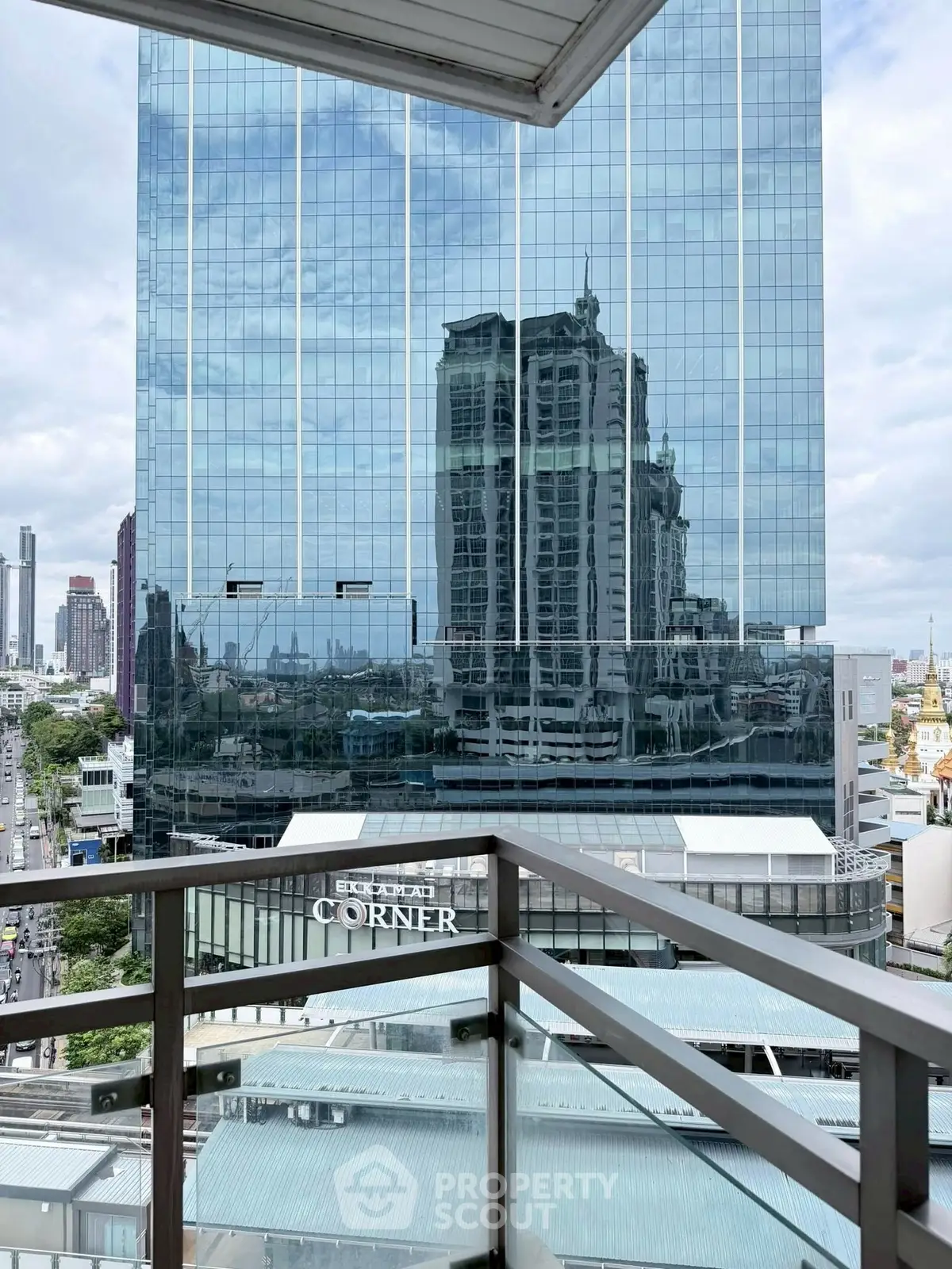 Stunning city view from a modern balcony with glass railing and skyscrapers.