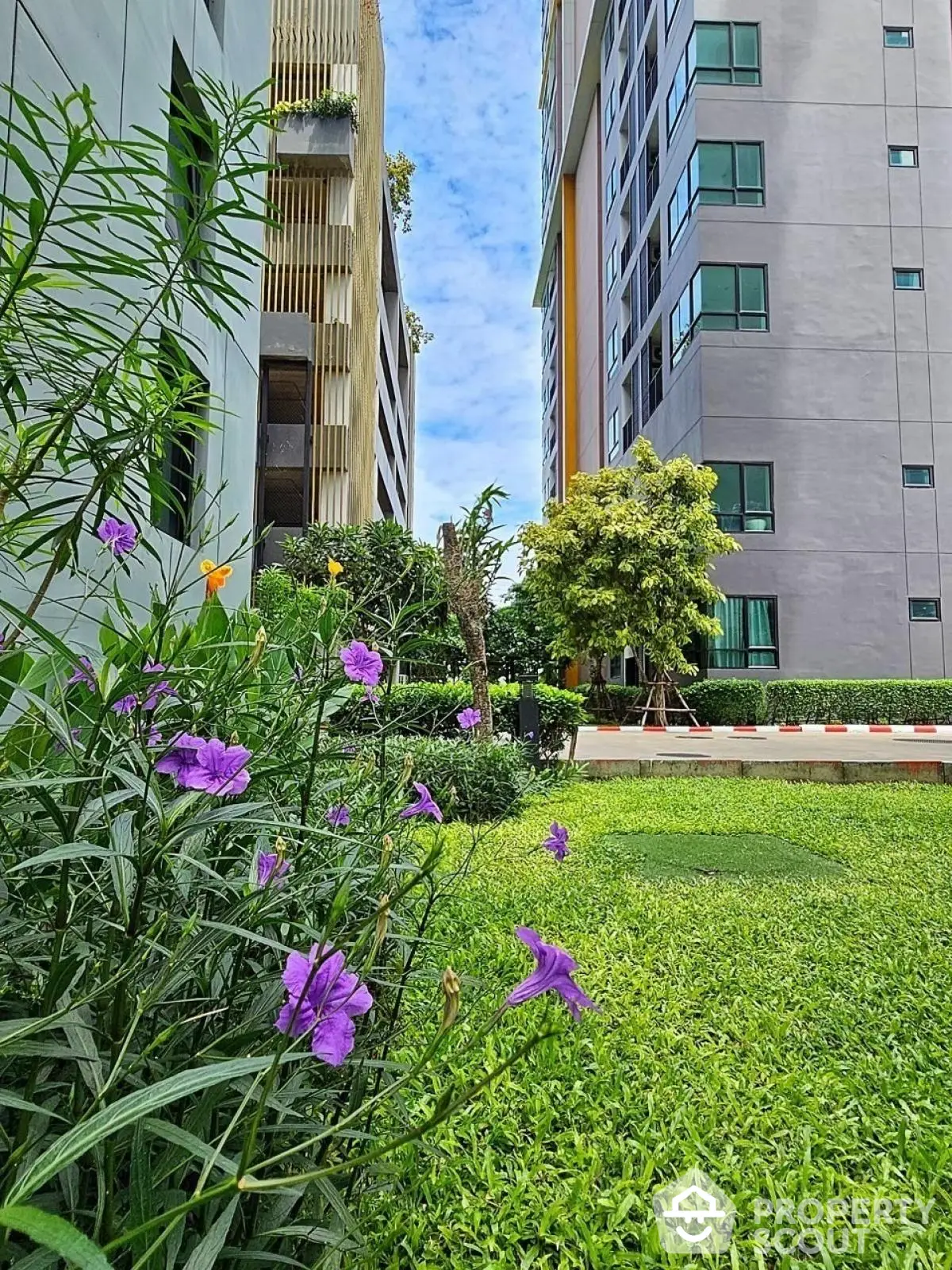 Modern apartment building with lush garden and vibrant flowers