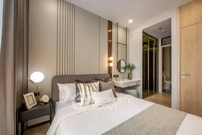 Modern bedroom with elegant decor, featuring a cozy bed, stylish lighting, and a sleek vanity area.