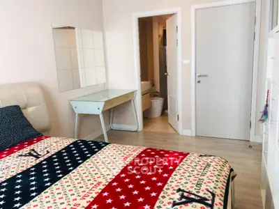 Cozy bedroom with stylish decor and ensuite bathroom in modern apartment.