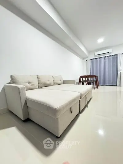 Spacious modern living room with sleek furniture and natural light, perfect for relaxation and entertaining.